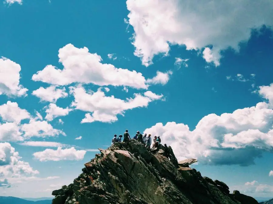 Blue summer sky with white clouds over a hilltop